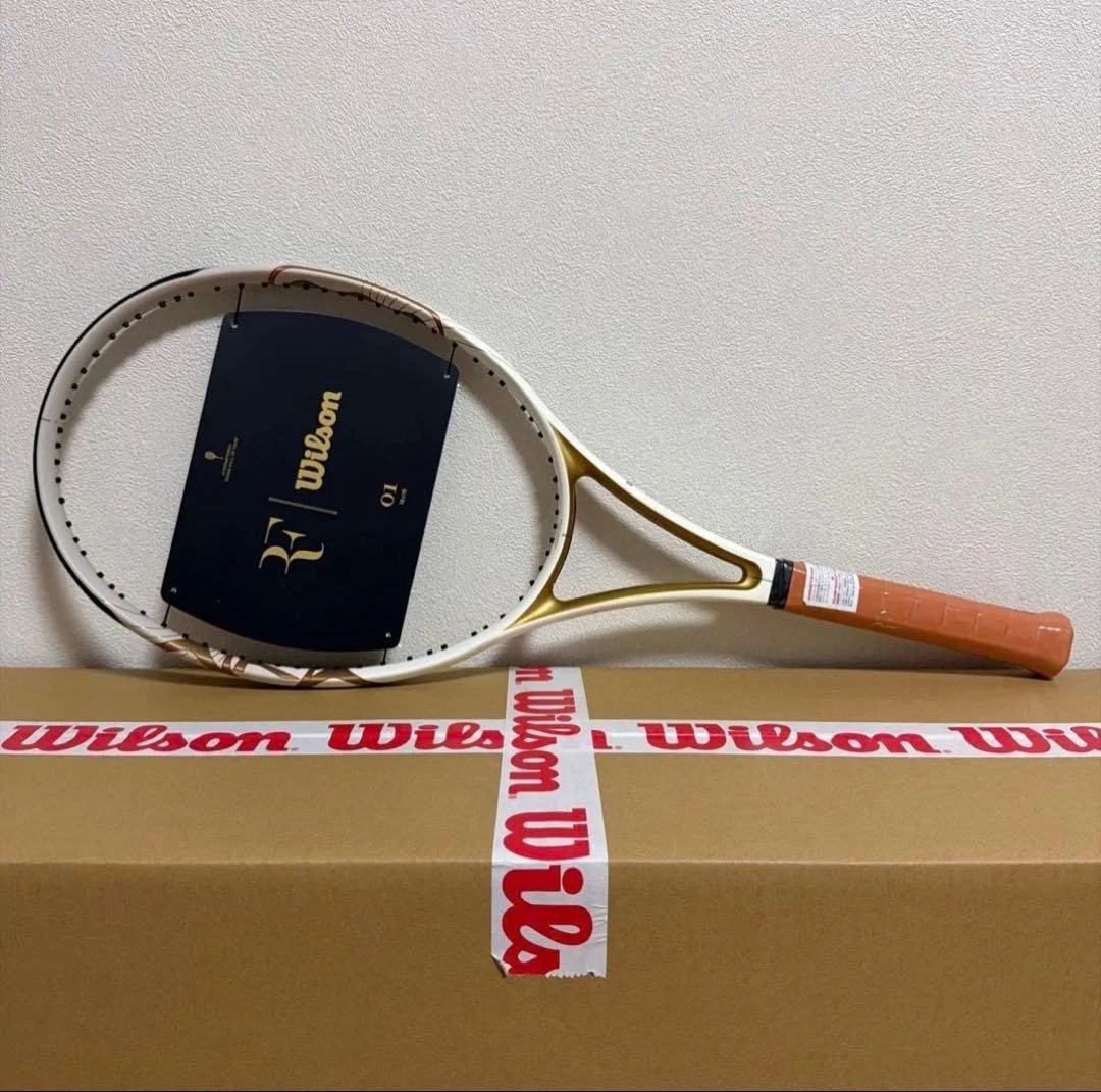 Wilson RF 01 racket in white and gold, new with tags, resting on a Wilson box